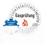 Gasprüfungsplakette mit Prüfziffern und dem Hinweis auf den nächsten Prüftermin, Sicherheitshinweis sichtbar.