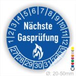 Mehrjahresplaketten, Prüfplaketten rund, Farbe- Blau, Text "Nächste Gasprüfung" in Weiß danach eine Flamme als Pictogramm oder Icon in Weiß, Startjahr- 27, Monatszahlen Oben und Jahreszahlen Unten in Kreisform.