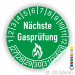 Mehrjahresplaketten, Prüfplaketten rund, Farbe- Grün, Text "Nächste Gasprüfung" in Weiß danach eine Flamme als Pictogramm oder Icon in Weiß, Startjahr- 27, Monatszahlen Oben und Jahreszahlen Unten in Kreisform.