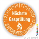 Mehrjahresplaketten, Prüfplaketten rund, Farbe- Orange, Text "Nächste Gasprüfung" in Weiß danach eine Flamme als Pictogramm oder Icon in Weiß, Startjahr- 27, Monatszahlen Oben und Jahreszahlen Unten in Kreisform.