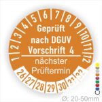Prüfplakette mit Text Geprüft nach Dguv Vorschrift 4 und Nächster Prüftermin mit zwischen Strich in Weiss. Plaketten Farbe- Orange und Text in Weiss. Monatszahlen oben und Jahreszahlen unten beginnend mit Startjahr- 26