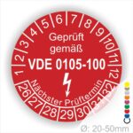 DIN VDE 0105 Prüfplakette rund, Text "geprüft gemäß VDE 0105-100" Farbe- Rot Startjahr- 26 mit Elektro Pfeil, Monatszahlen Oben und Jahreszahlen Unten