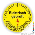 Prüfplaketten rund Farbe- Gelb, Text "Elektrisch geprüft" in Schwarz danach ein Elektro- Pfeil in Rot, Startjahr- 26, Monatszahlen Oben und Jahreszahlen Unten in Kreisform