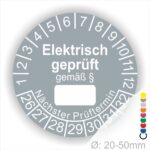 Pruefplakette mit Text Elektrisch geprüft gemäß Paragrapf als Zeichen und Beschriftungfeld zum eintragen des Paragraphs Farbe- Grau Startjahr- 26 mit Monatszahlen Oben und Jahreszahlen Unten Form ist Rund