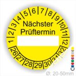 Prüfplakette, Prüfetikett rund, Farbe- Gelb, Text "Nächster Prüftermin" in Schwarz. Als nächstes kommt ein Beschriftungfeld / Leerfeld in Farbe Weiß. Startjahr- 26, Monatszahlen Oben und Jahreszahlen Unten in Kreisform.