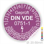 Prüfplaketten rund, Farbe- Lila, Text "Geprüft gemäß DIN VDE 0751-1" in Weiß danach ein Elektro- Pfeil in Weiß, Startjahr- 26, Monatszahlen Oben und Jahreszahlen Unten in Kreisform. Über den Jahreszahlen Text "Nächster Prüftermin"