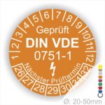 Prüfplaketten rund, Farbe- Orange, Text "Geprüft gemäß DIN VDE 0751-1" in Weiß danach ein Elektro- Pfeil in Weiß, Startjahr- 26, Monatszahlen Oben und Jahreszahlen Unten in Kreisform. Über den Jahreszahlen Text "Nächster Prüftermin"