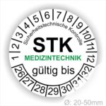 Pruefplaketten STK Medizintechnik Prüfetiketten rund, Farbe- Weiß, Text "Sicherheitstechnische Kontrolle, STK MEDIZINTECHNIK gültig bis" in Schwarz. Startjahr- 26, Monatszahlen Oben und Jahreszahlen Unten in Kreisform. über den Jahreszahlen Text.
