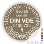 Prüfplaketten rund, Farbe- Braun, Text "Geprüft gemäß VDE 0100-0723" in Weiß danach ein Elektro- Pfeil in Weiß, Startjahr- 25, Monatszahlen Oben und Jahreszahlen Unten in Kreisform. Über den Jahreszahlen Text "Nächster Prüftermin"