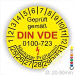 Prüfplaketten rund, Farbe- Gelb, Text "Geprüft gemäß VDE 0100-723" in Schwarz danach ein Elektro- Pfeil in Rot, Startjahr- 25, Monatszahlen Oben und Jahreszahlen Unten in Kreisform. Über den Jahreszahlen Text "Nächster Prüftermin"