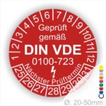 Prüfplaketten rund, Farbe- Rot, Text "Geprüft gemäß VDE 0100-0723" in Weiß danach ein Elektro- Pfeil in Weiß, Startjahr- 25, Monatszahlen Oben und Jahreszahlen Unten in Kreisform. Über den Jahreszahlen Text "Nächster Prüftermin"