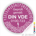 Prüfetiketten rund, Farbe- Lila, Text "Geprüft gemäß VDE 0100-0723" in Weiß danach ein Elektro- Pfeil in Weiß, Startjahr- 26, Monatszahlen Oben und Jahreszahlen Unten in Kreisform. Über den Jahreszahlen Text "Nächster Prüftermin"