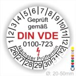 Prüfetiketten rund, Farbe- Weiß, Text "Geprüft gemäß VDE 0100-723" in Schwarz danach ein Elektro- Pfeil in Rot, Startjahr- 26, Monatszahlen Oben und Jahreszahlen Unten in Kreisform. Über den Jahreszahlen Text "Nächster Prüftermin"