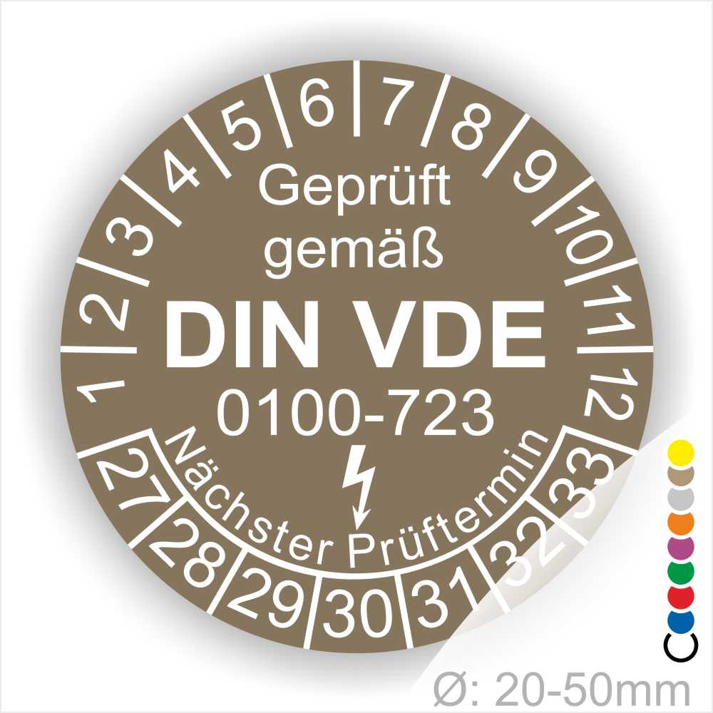 Prüfaufkleber rund, Farbe- Braun, Text "Geprüft gemäß VDE 0100-0723" in Weiß danach ein Elektro- Pfeil in Weiß, Startjahr- 27, Monatszahlen Oben und Jahreszahlen Unten in Kreisform. Über den Jahreszahlen Text "Nächster Prüftermin"