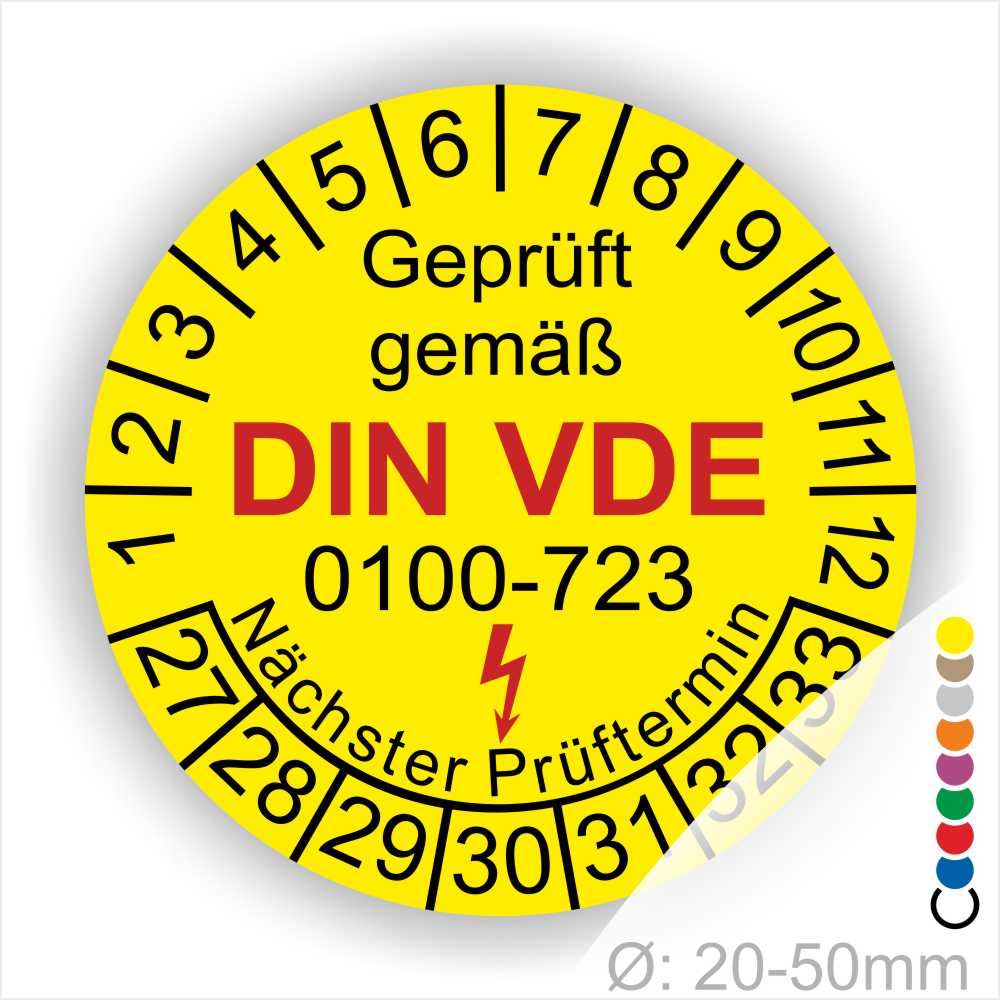 Prüfaufkleber rund, Farbe- Gelb, Text "Geprüft gemäß VDE 0100-723" in Schwarz danach ein Elektro- Pfeil in Rot, Startjahr- 27, Monatszahlen Oben und Jahreszahlen Unten in Kreisform. Über den Jahreszahlen Text "Nächster Prüftermin"