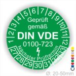 Prüfaufkleber rund, Farbe- Grün, Text "Geprüft gemäß VDE 0100-0723" in Weiß danach ein Elektro- Pfeil in Weiß, Startjahr- 27, Monatszahlen Oben und Jahreszahlen Unten in Kreisform. Über den Jahreszahlen Text "Nächster Prüftermin"