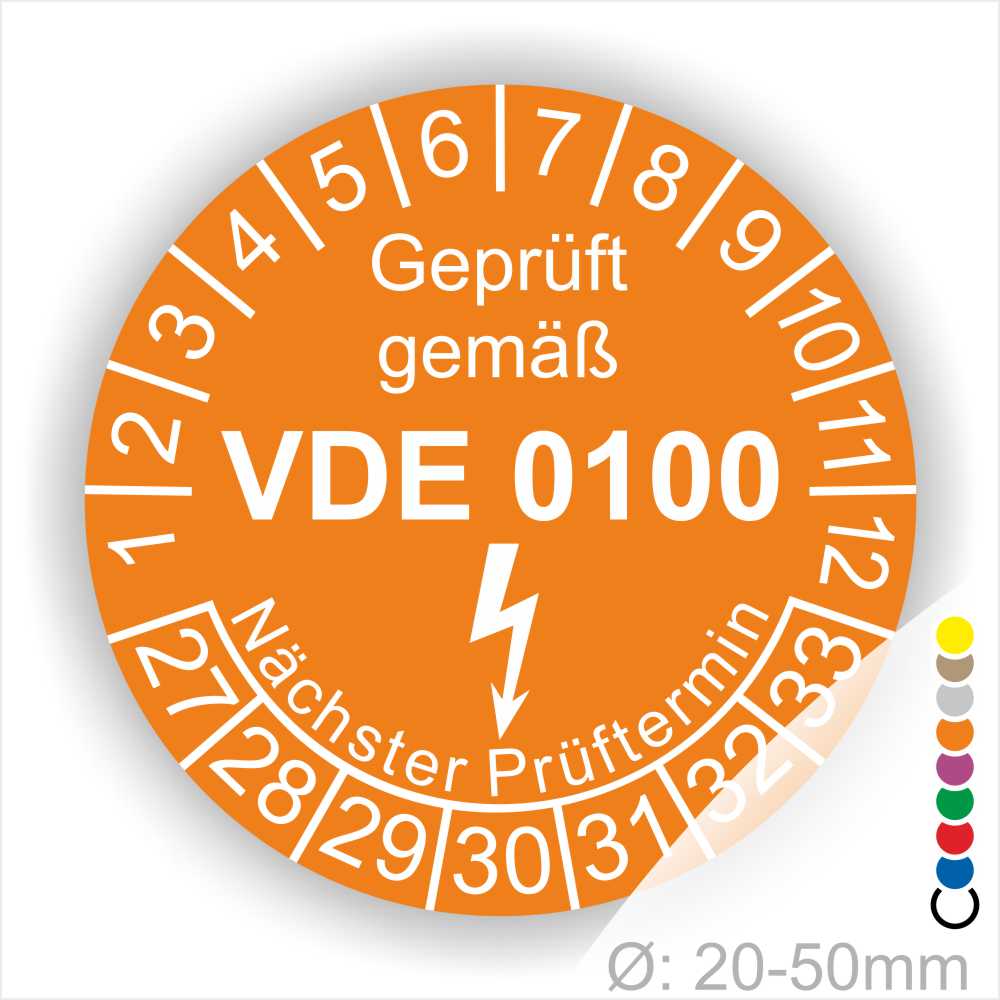 Prüfaukleber rund, Farbe- Orange, Text "Geprüft gemäß VDE 0100" in Weiß danach ein Elektro- Pfeil in Weiß, Startjahr- 27, Monatszahlen Oben und Jahreszahlen Unten in Kreisform. Über den Jahreszahlen Text "Nächster Prüftermin"