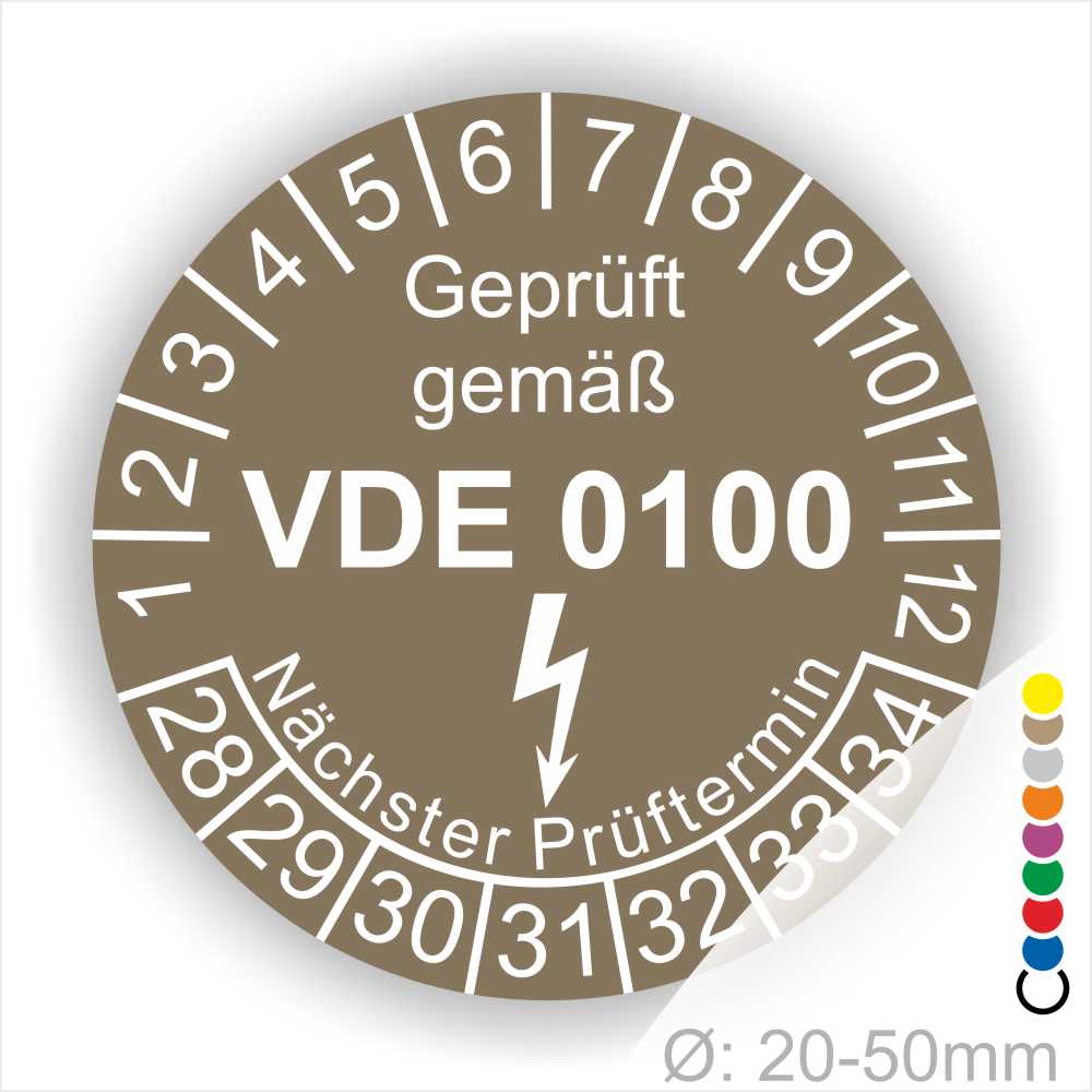 Prüfetikette rund, Farbe- Braun, Text "Geprüft gemäß VDE 0100" in Weiß danach ein Elektro- Pfeil in Weiß, Startjahr- 28, Monatszahlen Oben und Jahreszahlen Unten in Kreisform. Über den Jahreszahlen Text "Nächster Prüftermin"