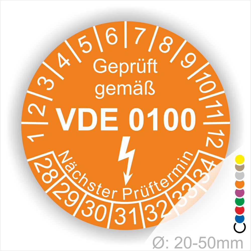 Prüfetikette rund, Farbe- Orange, Text "Geprüft gemäß VDE 0100" in Weiß danach ein Elektro- Pfeil in Weiß, Startjahr- 28, Monatszahlen Oben und Jahreszahlen Unten in Kreisform. Über den Jahreszahlen Text "Nächster Prüftermin"