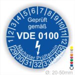 Prüfetikette rund, Farbe- Blau, Text "Geprüft gemäß VDE 0100" in Weiß danach ein Elektro- Pfeil in Weiß, Startjahr- 29, Monatszahlen Oben und Jahreszahlen Unten in Kreisform. Über den Jahreszahlen Text "Nächster Prüftermin"