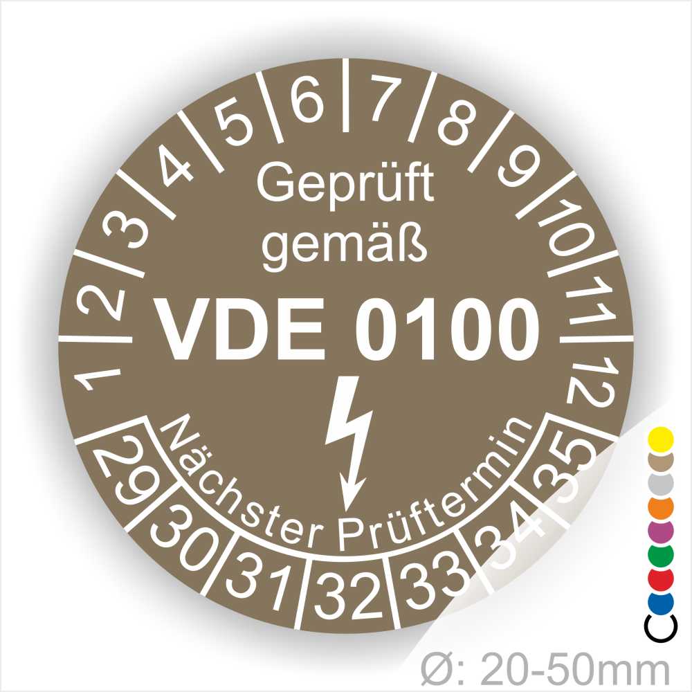 Prüfetikette rund, Farbe- Braun, Text "Geprüft gemäß VDE 0100" in Weiß danach ein Elektro- Pfeil in Weiß, Startjahr- 29, Monatszahlen Oben und Jahreszahlen Unten in Kreisform. Über den Jahreszahlen Text "Nächster Prüftermin"