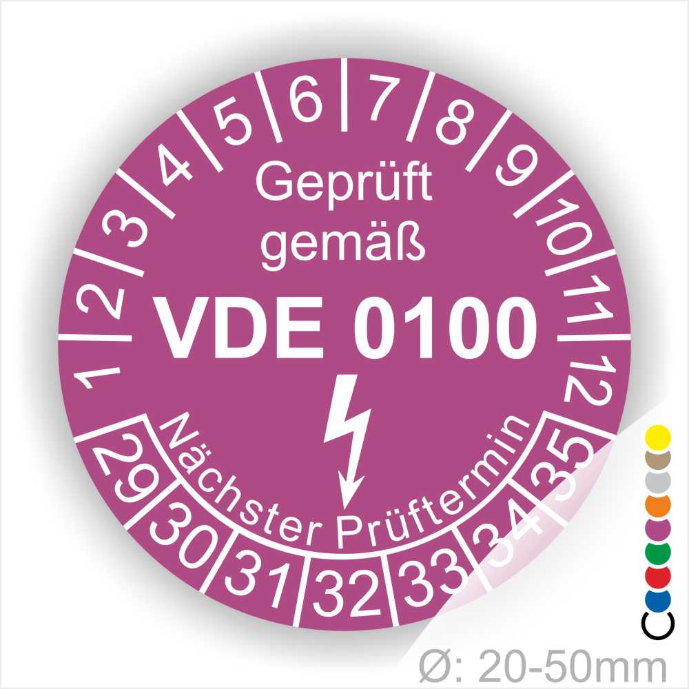 Prüfetikette rund, Farbe- Lila, Text "Geprüft gemäß VDE 0100" in Weiß danach ein Elektro- Pfeil in Weiß, Startjahr- 29, Monatszahlen Oben und Jahreszahlen Unten in Kreisform. Über den Jahreszahlen Text "Nächster Prüftermin"