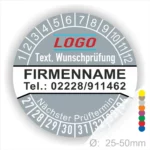 Graue Prüfplakette mit Monats- und Jahresring zur Kennzeichnung des nächsten Prüftermins, personalisierbar mit Firmenname, Logo, Telefonnummer und Wunschtext. Selbstklebender Prüfaufkleber für Wartung, Sicherheitsprüfung und Betriebsmittelkennzeichnung.