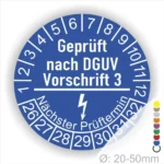 Prüfsiegel nach DGUV Vorschrift 3, blaues Rundzeichen mit nächstem Prüftermin und Durchmesserangabe von 20-50 mm.