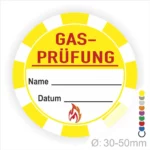 Gelbes Schild für Gasprüfungen mit Platz für Name und Datum, Durchmesser von 30-50 mm, inklusive Flammensymbol. Ideal für Sicherheitskennzeichnung in technischen Bereichen.
