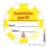 Gasbehälter Prüfaufkleber mit Platz für Name und Datum, gelbes Design mit rotem Text und Flammensymbol, Durchmesser von 30-50 mm.