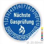 Blaues Schild mit der Aufschrift "Nächste Gasprüfung" und Zahlen von 1 bis 32, um den nächsten Prüftermin zu kennzeichnen. Symbol eines Feuers im unteren Bereich, geeignet für Gasinstallationen. Durchmesser von 20-50 mm.