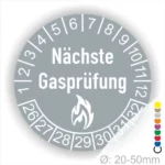 Runder Aufkleber mit der Aufschrift "Nächste Gasprüfung" und einem Flammensymbol. Das Design enthält Zahlen von 1 bis 31 zur Markierung des nächsten Prüftermins. Ideal für die Kennzeichnung von Gasprüfungen in Gebäuden. Durchmesser: 20-50 mm.