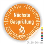 Runder Aufkleber zur Anzeige der nächsten Gasprüfung mit orangefarbener Hintergrundfarbe, weißen Zahlen von 1 bis 30 und einem Flammensymbol. Durchmesser von 20 bis 50 mm.