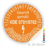 Prüfzertifikat in orange für elektrische Geräte, gemäß VDE 0701/0702, mit Angabe des nächsten Prüftermins und Durchmesser von 20-50 mm.