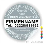 Bild eines Prüfaufklebers, der nach DGUV Vorschrift 3 zertifiziert ist. Enthält Informationen wie Firmenname, Telefonnummer, Adresse und den nächsten Prüftermin. Der Aufkleber hat einen Durchmesser von 25-50 mm und zeigt farbige Markierungen.