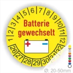 Prüfaufkleber, Prüfplakette rund, Farbe- Gelb, Text "Batterie gewechselt" in Rot. Icon Batterie, Startjahr- 26, Monatszahlen Oben und Jahreszahlen Unten in Kreisform.