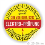Runde Elektroprüfungs-Plakette mit dem Aufdruck "Geprüft gemäß DIN VDE 0701/0702" und dem Hinweis auf den nächsten Prüftermin. Die Plakette ist gelb mit roten und schwarzen Schriftzügen und hat einen Durchmesser von 25-50 mm.