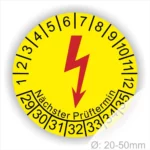 Gelbes Prüfplakett mit einem Blitzsymbol, das den nächsten Prüftermin anzeigt. Die Skala reicht von 1 bis 12 für Monate und 29 bis 35 für Jahre. Geeignet für Geräte mit einem Durchmesser von 20 bis 50 mm.