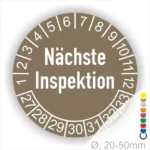 Runder Aufkleber zur Anzeige des nächsten Inspektionsdatums, orangebraunZahlen von 1 bis 12 und Jahreszahlen 27-33, Durchmesser von 20-50 mm.