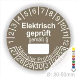 Runde Prüfungsscheibe für elektrische Geräte, beschriftet mit „Elektrisch geprüft gemäß §“. Enthält Platz für das Datum des nächsten Prüftermins und Zahlen von 1 bis 12 sowie 27 bis 33. Ideal für die Einhaltung von Sicherheitsstandards.