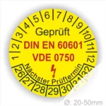 Runde gelbe Prüfplakette „Geprüft DIN EN 60601 VDE 0750“ für medizinische elektrische Geräte mit Monatsring und Jahresring, Blitzsymbol und Aufdruck „Nächster Prüftermin“, Ø 20–50 mm