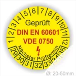 Gelbes Prüfzeichen mit den Normen DIN EN 60601 und VDE 0750, das den nächsten Prüftermin anzeigt. Durchmesser von 20-50mm, geeignet für die Kennzeichnung von elektrischen Geräten.