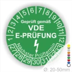 Grünes Prüfzeichen für elektrische Geräte, geprüft gemäß VDE E-Prüfung, mit Angabe des nächsten Prüftermins und Durchmesser von 20-50 mm.